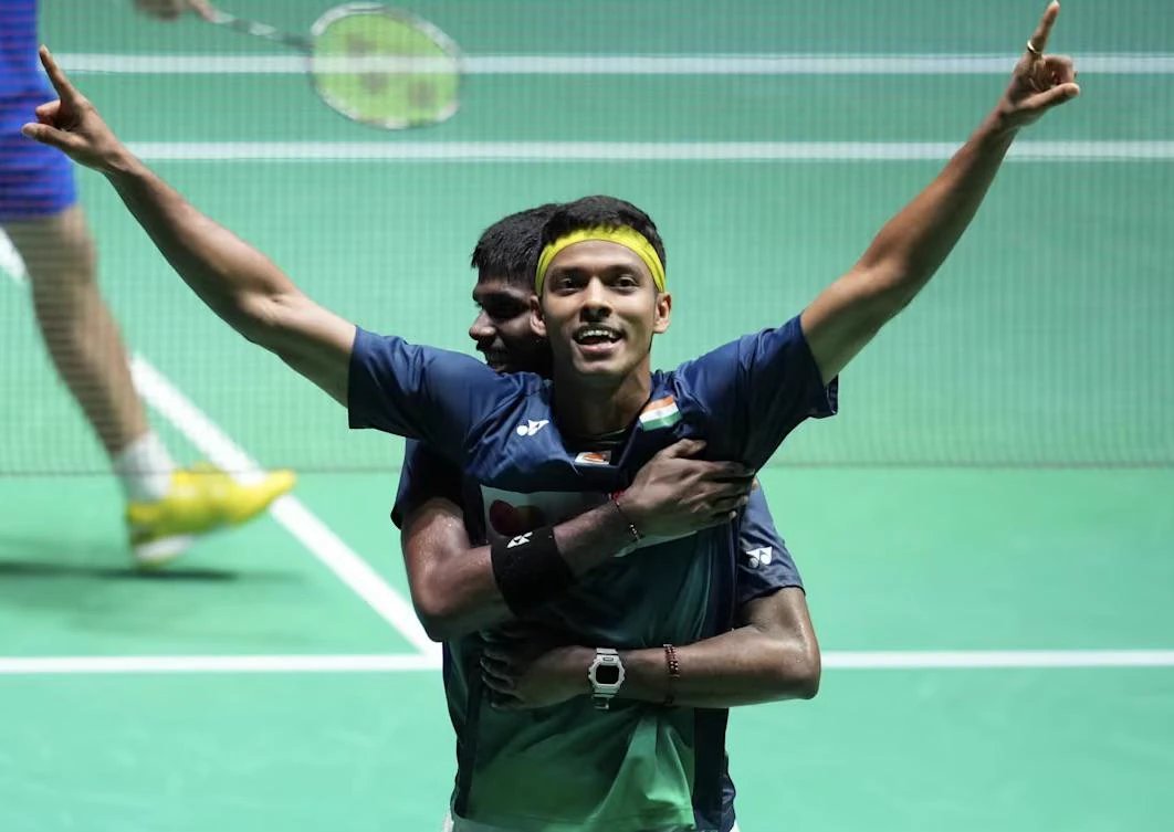 Satwiksairaj Rankireddy and Chirag Shetty celebrating a men’s doubles win, arms raised on court.